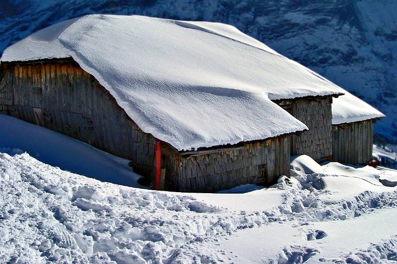 Verschneite Hütte auf der First-Seite