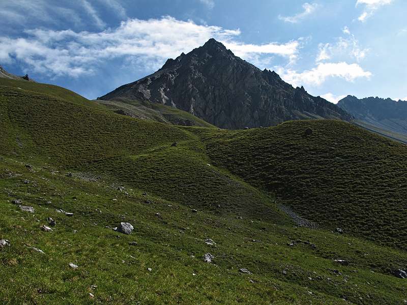 Der Gipfel von Piz dal Botch und die schöne, grüne Hügel