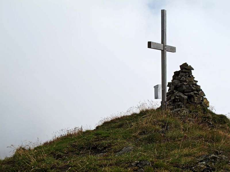 Das Gipfelkreuz von Zuestoll. Walensee ist bereits im Nebel