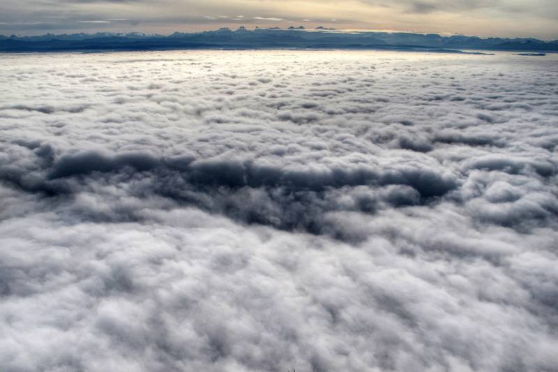 Unsten ist alles im Nebel. Am Horizont sind die bekannten Berner-Gipfel