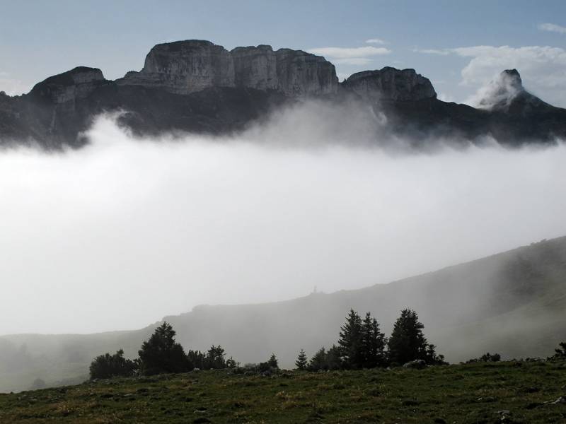 Plötzlich Nebel sinkt nach unten und die umliegenden Berge sind sichtbar