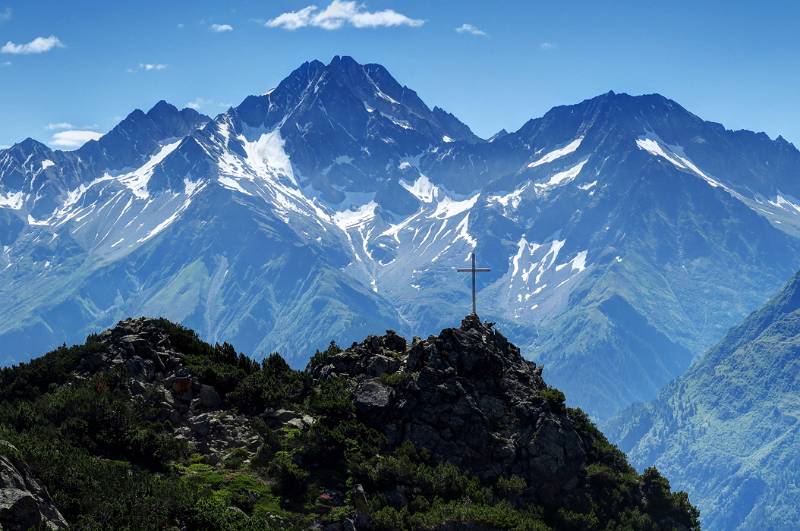 Bescheidener Gipfel von Sunnig Grat im Hintergrund von grösseren Urner Bergen